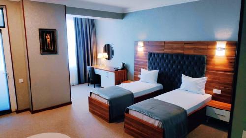 巴库Royal Boutique Baku的酒店客房配有两张床和一张书桌