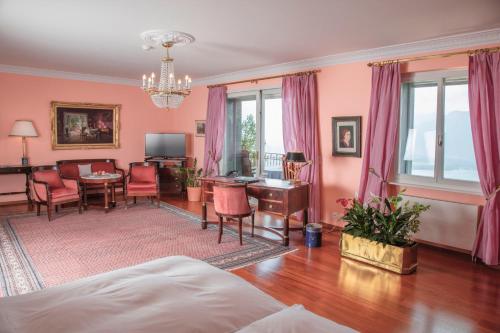 蒙特勒格里昂维多利亚酒店的客厅设有粉红色的墙壁和桌椅
