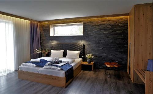 FunfseenPrivat & Boutique Hotel Plauer See的一间卧室设有一张床和砖墙