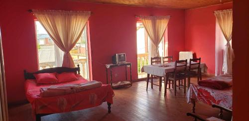 塔那那利佛Antsaly的客厅设有红色的墙壁、桌子和沙发