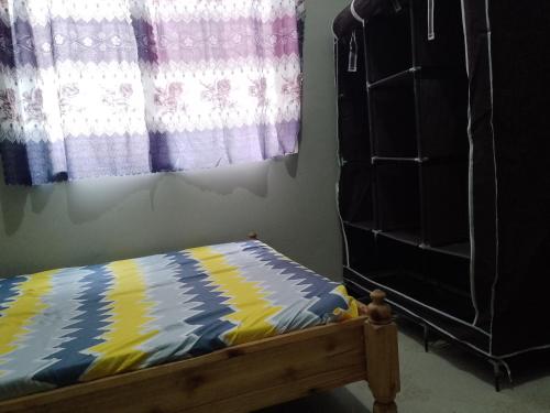 Sao HillMisyie's HomeStay的一间卧室配有一张床、一个梳妆台和一扇窗户。