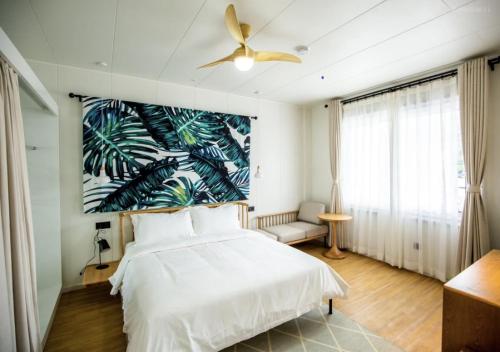 加拉班Discovery Saipan Hotel的卧室配有白色的床和吊扇