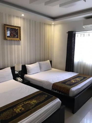 Mỹ PhướcKhách Sạn Lệ Hằng的一间卧室设有两张床和窗户。