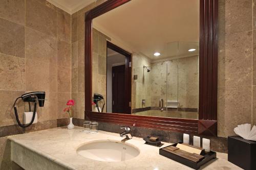 北干巴鲁北干巴鲁阿里亚酒店的一间带水槽和大镜子的浴室