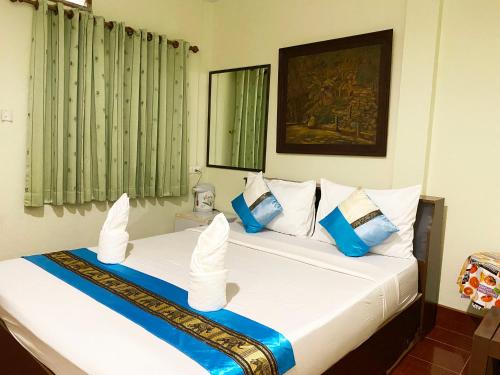 蔻立考拉城市大酒店的一间卧室配有两张带蓝白色枕头的床