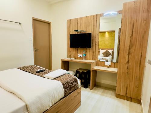 钦奈Stay Court - Business Class Hotel - Near Central Railway Station的酒店客房配有一张床、一张书桌和一台电视。