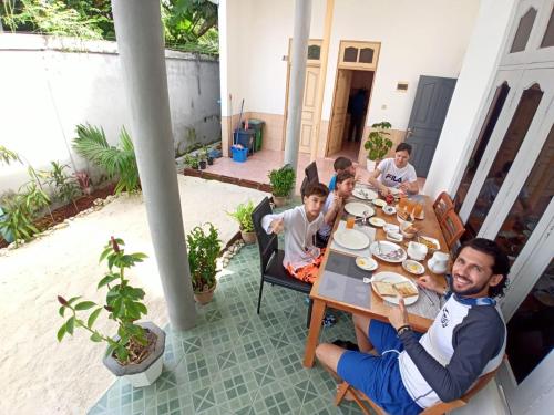 VaikaradhooBoegas View Guesthouse的一群坐在桌子上吃食物的孩子