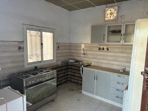 乌姆莱季استراحة الريان的厨房配有炉灶、水槽和窗户。