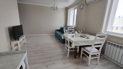 PrigorodnyyKamal Apart的客厅配有桌子和沙发