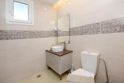 克雷马斯蒂Elli Garden View - Spacious Fully Equipped Apartment的白色的浴室设有卫生间和水槽。