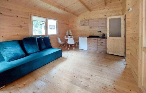 波别罗沃Beautiful Home In Pobierowo With Kitchen的一间带蓝色沙发的客厅和一间厨房