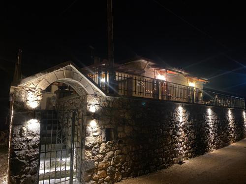 维蒂纳Methydrion Country House的夜间用灯光打造的石墙
