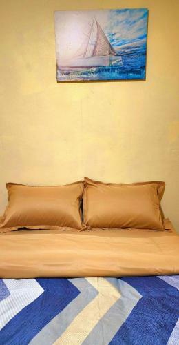 劳托卡Acacia Gardens的一张带两个枕头的床和墙上的绘画