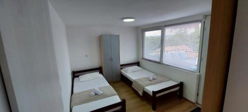 比利切Sydney Apartment的小房间设有两张床和窗户