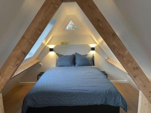 瓦瑟纳尔Cottage Guest House in Wassenaar的阁楼卧室配有蓝色床