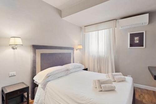 佛罗伦萨Tornabuoni Living - Luxury Apartments Collection的卧室配有白色的床和2条毛巾