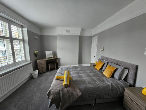 莱斯特Knighton Villa的一间卧室配有一张带黄色枕头的大床