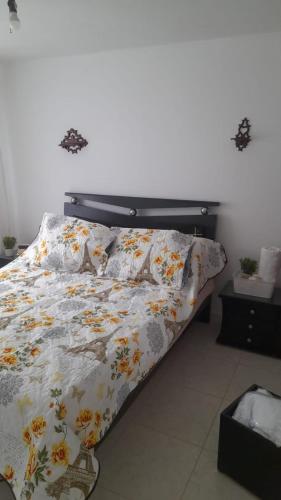 波哥大El descanso的卧室内的一张带花卉棉被的床