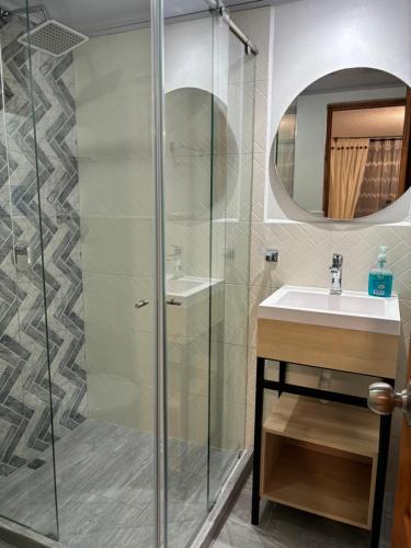 莱瓦镇Merak Hostel的一间带玻璃淋浴和水槽的浴室