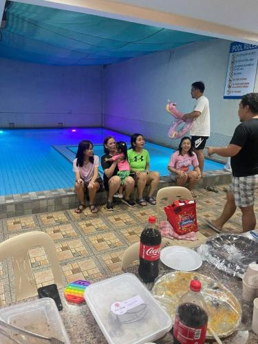 Bacoorvilla barbara的一群坐在游泳池前的儿童