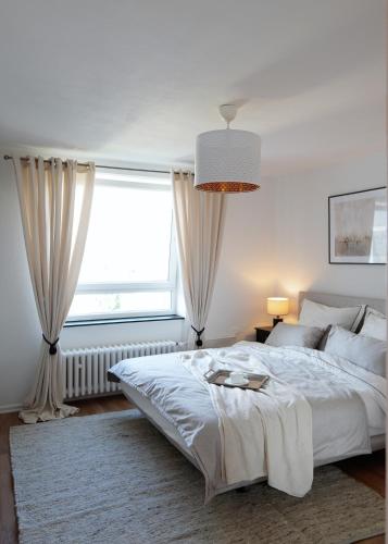汉诺威Elegantes & Modernes Messe Apartment, Hannover, Laatzen的一间卧室设有一张大床和一个窗户。