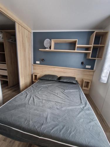 圣让-德蒙Louons ensemble的一间卧室配有一张带木制架子的大床