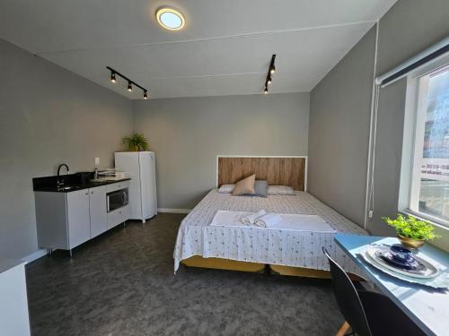 布卢梅瑙Residenz100的一间卧室配有一张床、一台冰箱和一张桌子