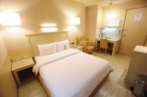 高雄康桥商旅 - 六合夜市中正馆的酒店客房设有一张大床和一张书桌。