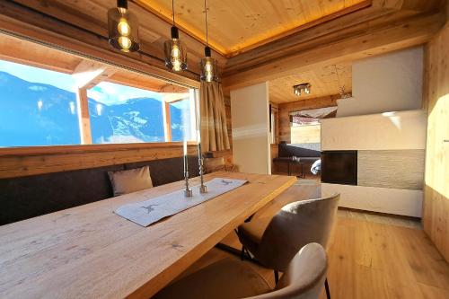 奇勒谷地拉姆绍Chalet - Das Schrofen的一间带木桌和椅子的用餐室