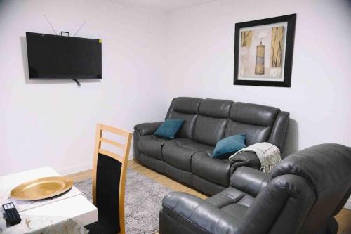 锡德卡普6 bedroom property的客厅配有真皮沙发和电视