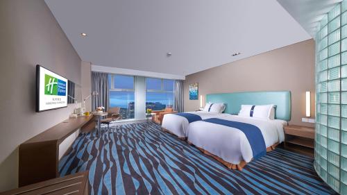 杭州杭州黄龙智选假日酒店的酒店客房设有一张大床和一台电视。