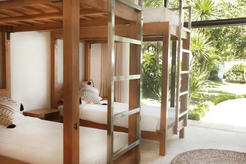 坎古Wave House - Surf Camp的一间卧室设有两张双层床和一扇窗户。