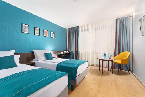 克雷费尔德Trip Inn Hotel Krefeld的酒店客房设有两张床和一张桌子。