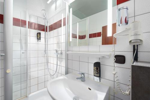 克雷费尔德Trip Inn Hotel Krefeld的白色的浴室设有水槽和镜子