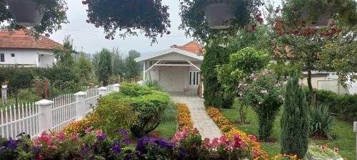 维索科Holiday Home Peaceful Retreat的花园前的白色围栏,花朵盛开