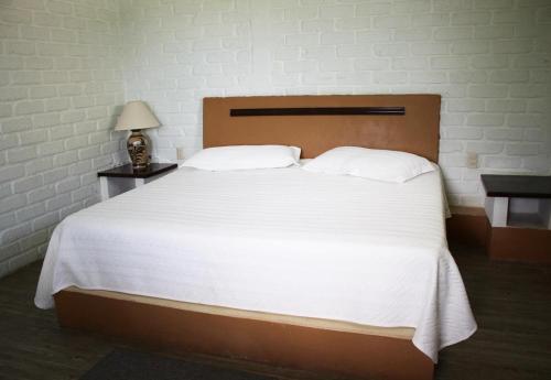 圣胡安科萨拉马玛楚依酒店的一间卧室配有一张带白色床单的大床