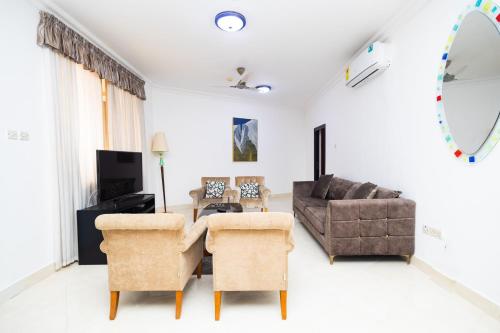 阿克拉Stay Play Away Residences - 3 bed, Airport Residential, Accra的客厅配有沙发和桌椅