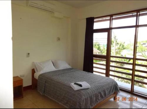 YurimaguasHostal El Puerto的一间卧室设有一张床和一个大窗户