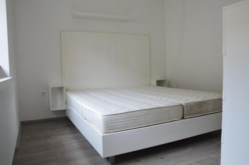 松博特海伊Haus Im Zentrum L mit 2 Schlafzimmer und garten的白色墙壁间的一张床