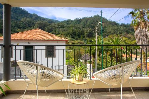 圣维森特A Casa da Tia的阳台设有两把椅子,享有房子的景色