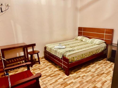 普卡尔帕Hotel Juan Diego Pucallpa的一间卧室配有一张床、一张桌子和一张桌子