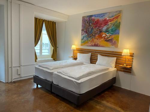 SeegräbenHotel Swiss Bellevue Aathal的一间卧室设有两张床,墙上挂着一幅画