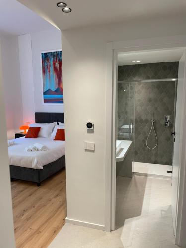 那不勒斯Rolando Domus的一间卧室配有一张床,浴室设有淋浴。