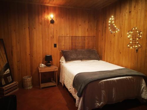 圣佩德罗拉拉古纳Linda vista的卧室配有木墙内的一张床