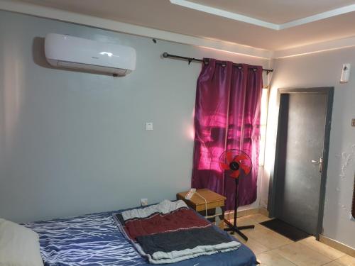 WupaShared space accommodation的一间卧室配有一张床和粉红色窗帘