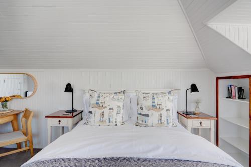 赫曼努斯Beautiful Abalone的卧室配有一张白色床、两张桌子和两盏灯。