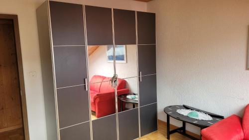 KönizSehr gemütliches und gepflegtes Zimmer 8 Km von Bern-City的一间房间里带红色沙发的大型灰色橱柜