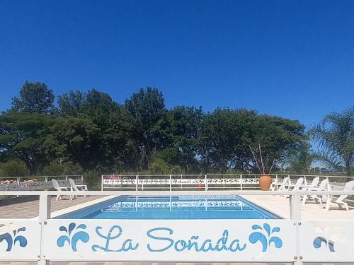 查哈里Cabañas La Soñada的一个带椅子的游泳池,一个栅栏上的标志