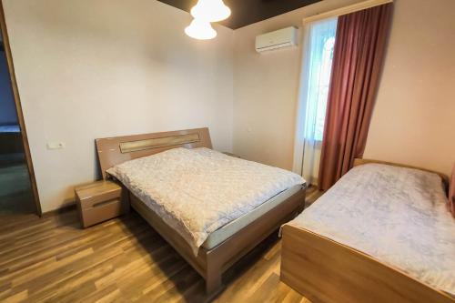 库塔伊西Mango's Guesthouse的一间卧室设有两张床和窗户。