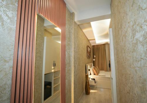 伊斯坦布尔Luxury Medea Taksim Hotel的走廊上设有镜子和一张位于客房内的床